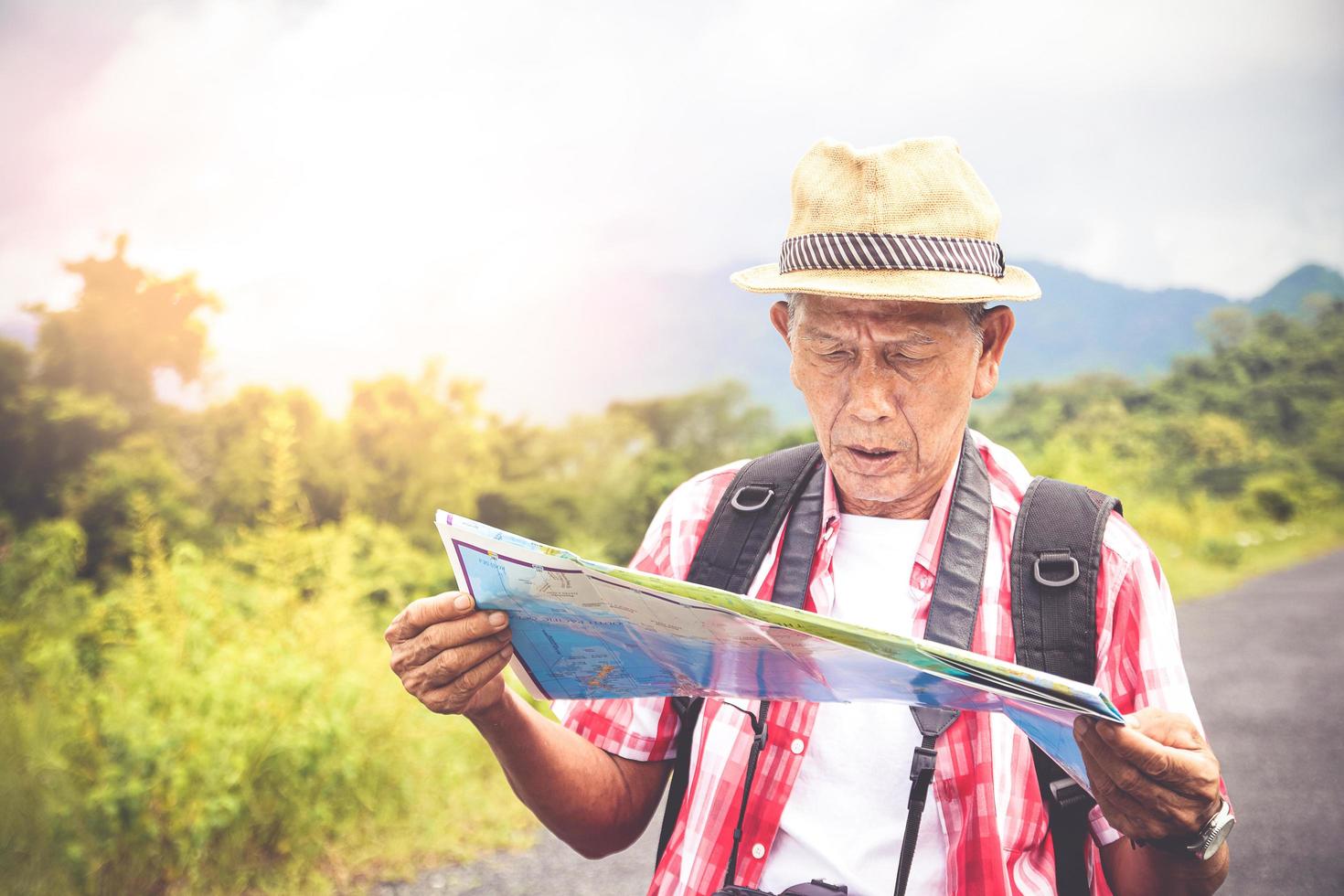 Senioren-Rucksackwandern öffnen eine Papierkarte, um die natürliche Touristenroute zu studieren. das konzept des glücklichen lebens nach der pensionierung. mit Kopierbereich. foto