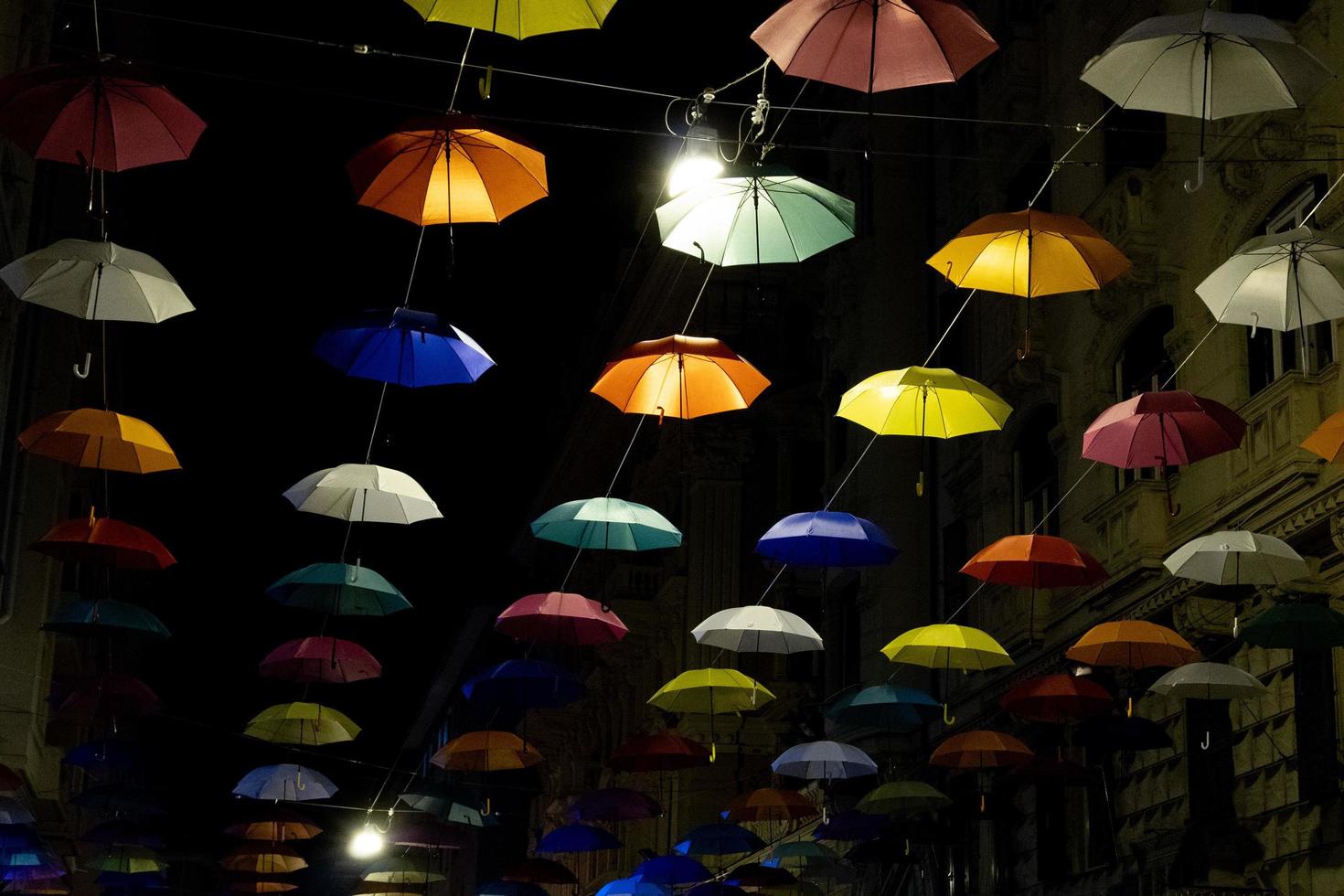 Regenschirme hängen nachts von den Straßen der Stadt in Genua für die Euroflora Expo foto