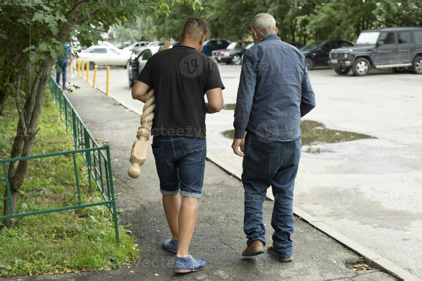 Männer gehen im Sommer ins Geschäft. Menschen im Hof des Hauses. Jung und Alt versammelten Fall. foto