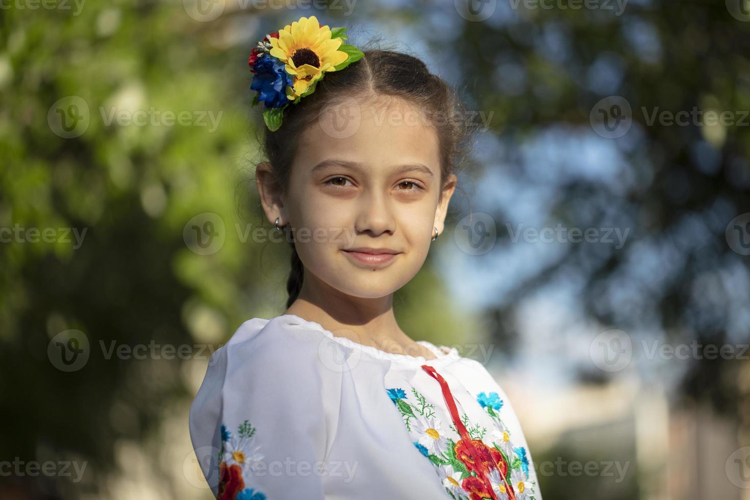 Ein kleines ukrainisches und weißrussisches Mädchen in einem bestickten Hemd auf sommerlichem Hintergrund. foto