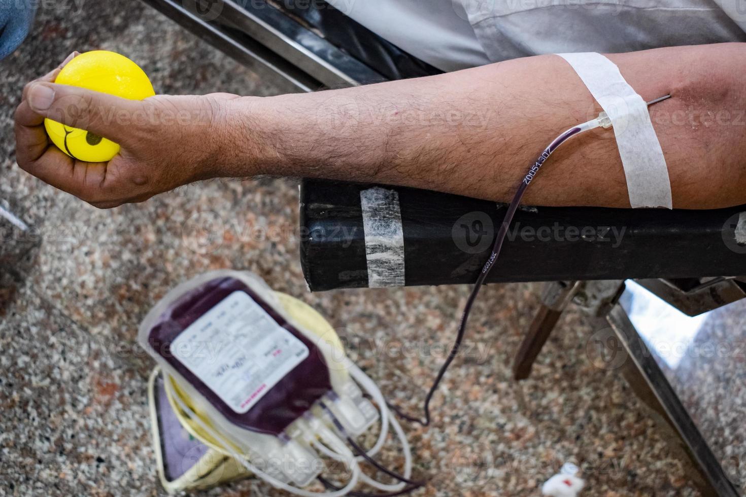 blutspender im blutspendecamp mit einem hüpfball in der hand gehalten im balaji-tempel, vivek vihar, delhi, indien, bild für den weltblutspendetag am 14. juni jedes jahr, blutspendecamp foto