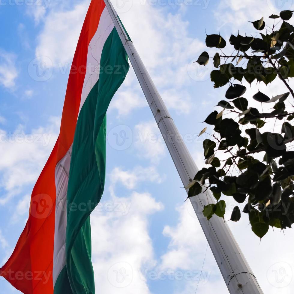 Indien-Flagge, die hoch am Connaught-Platz mit Stolz auf den blauen Himmel fliegt, Indien-Flagge flattert, indische Flagge am Unabhängigkeitstag und Tag der Republik Indien, Schuss nach oben geneigt, indische Flagge schwenkend, Har Ghar Tiranga foto