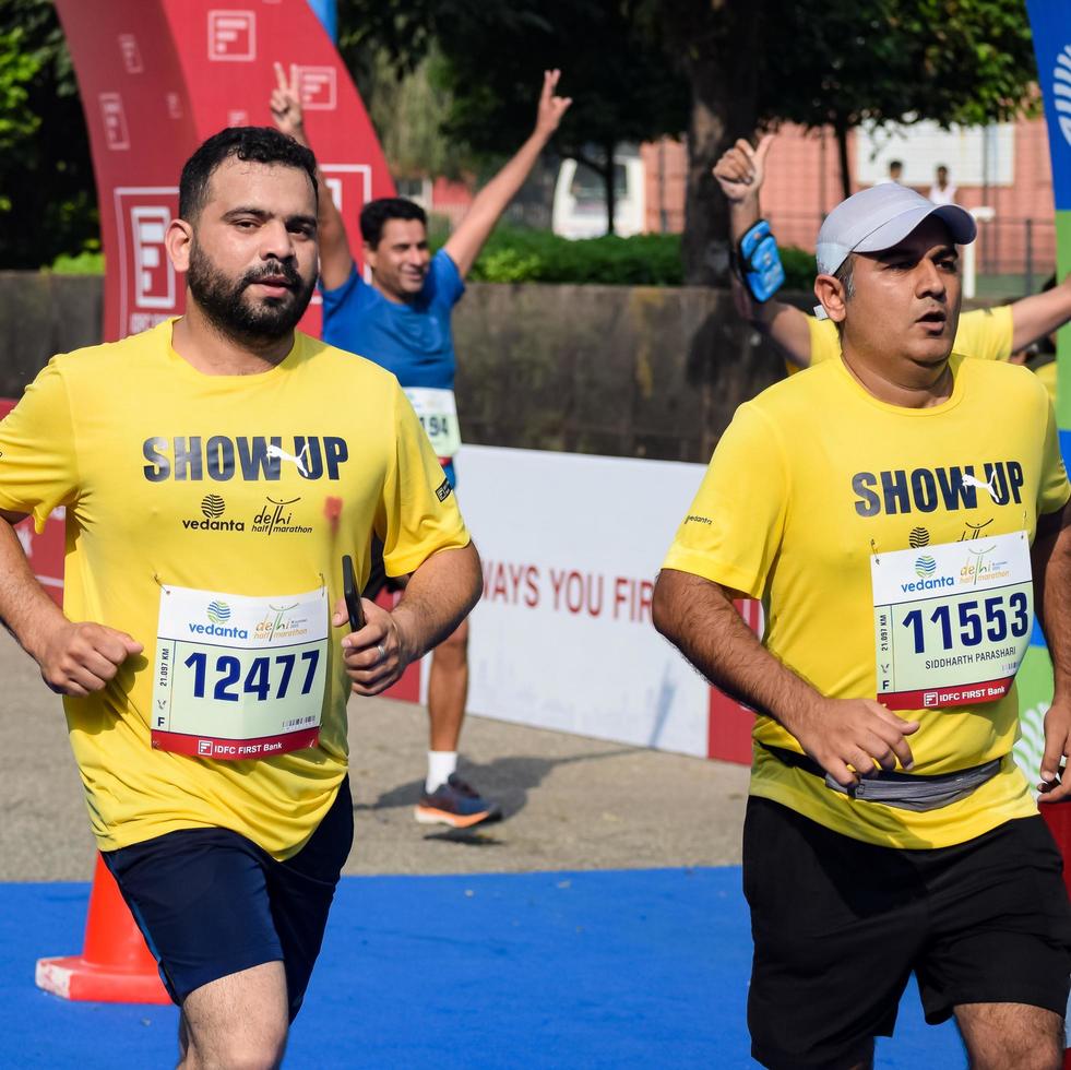 neu delhi, indien - 16. oktober 2022 - vedanta delhi halbmarathonrennen nach covid, bei dem die marathonteilnehmer kurz vor dem überqueren der ziellinie stehen, delhi halbmarathon 2022 foto