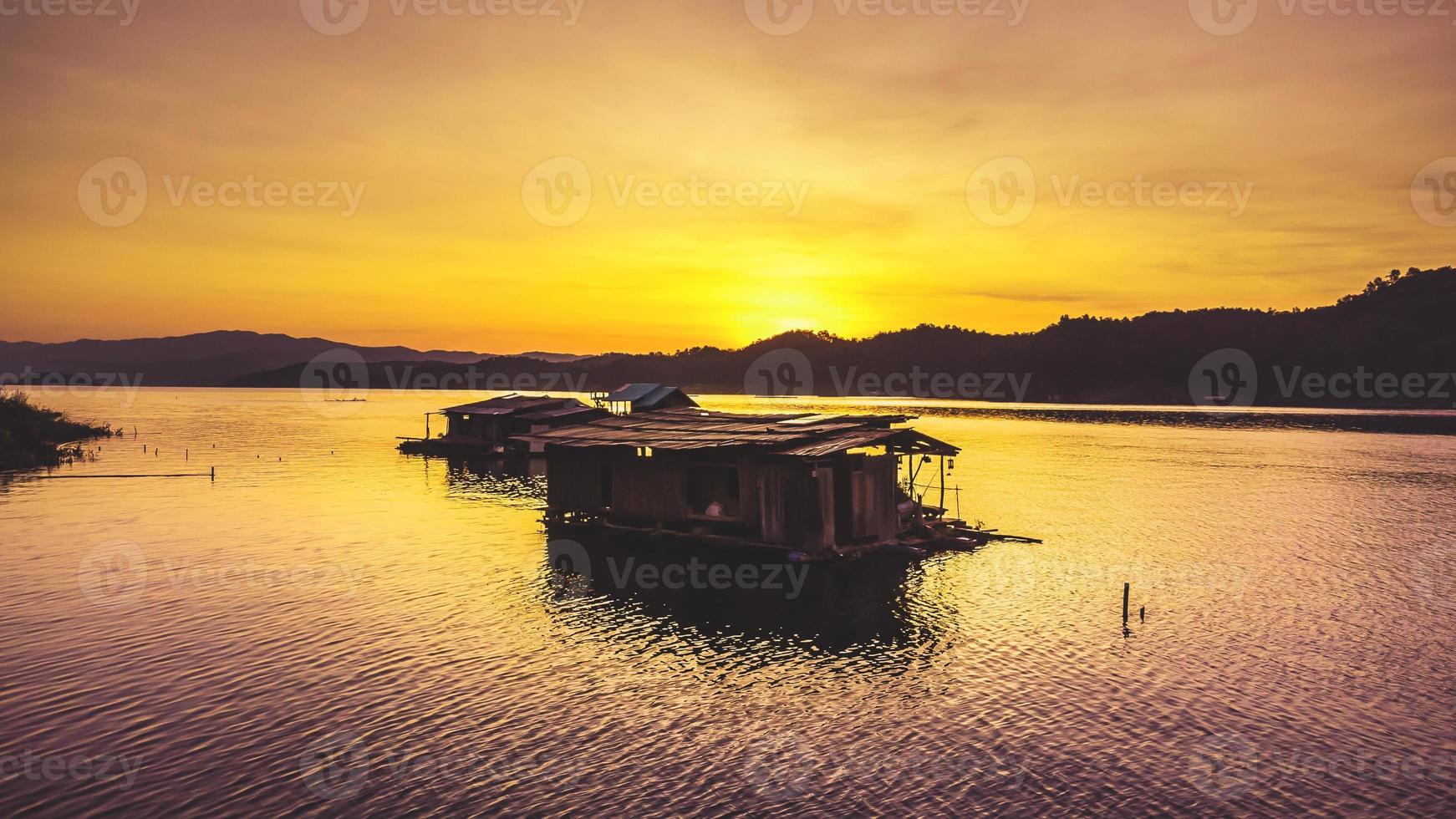 luftaufnahme des landschaftssonnenuntergangs mit stausee und floßhaus thailand foto