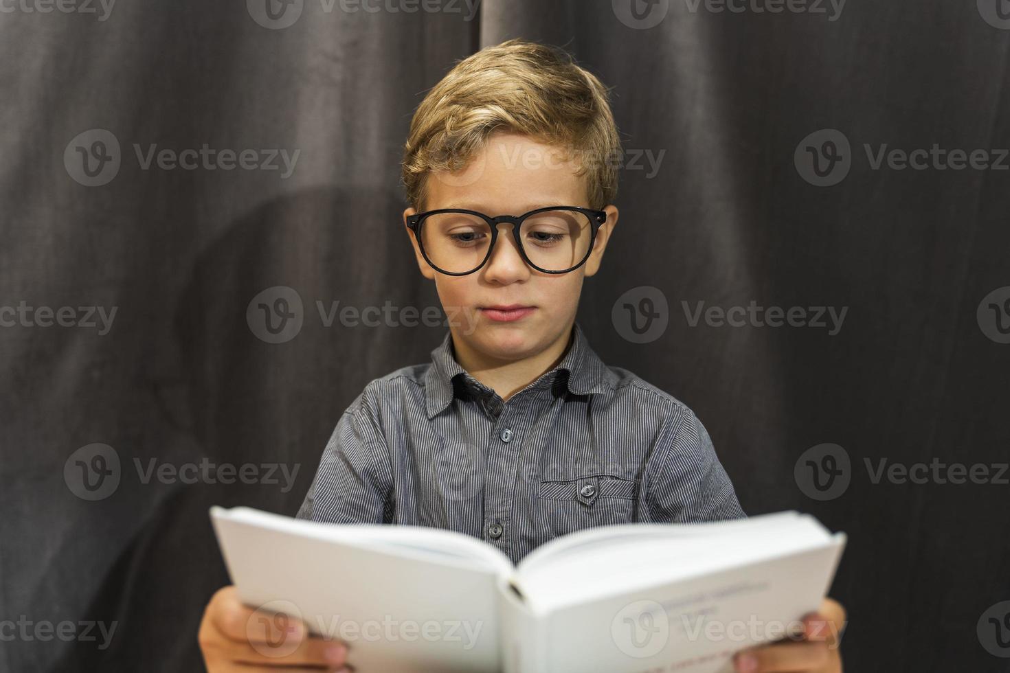 Junge liest ein Buch, Junge mit Brille, Bildung, Schulanfang, Lernschwierigkeiten foto