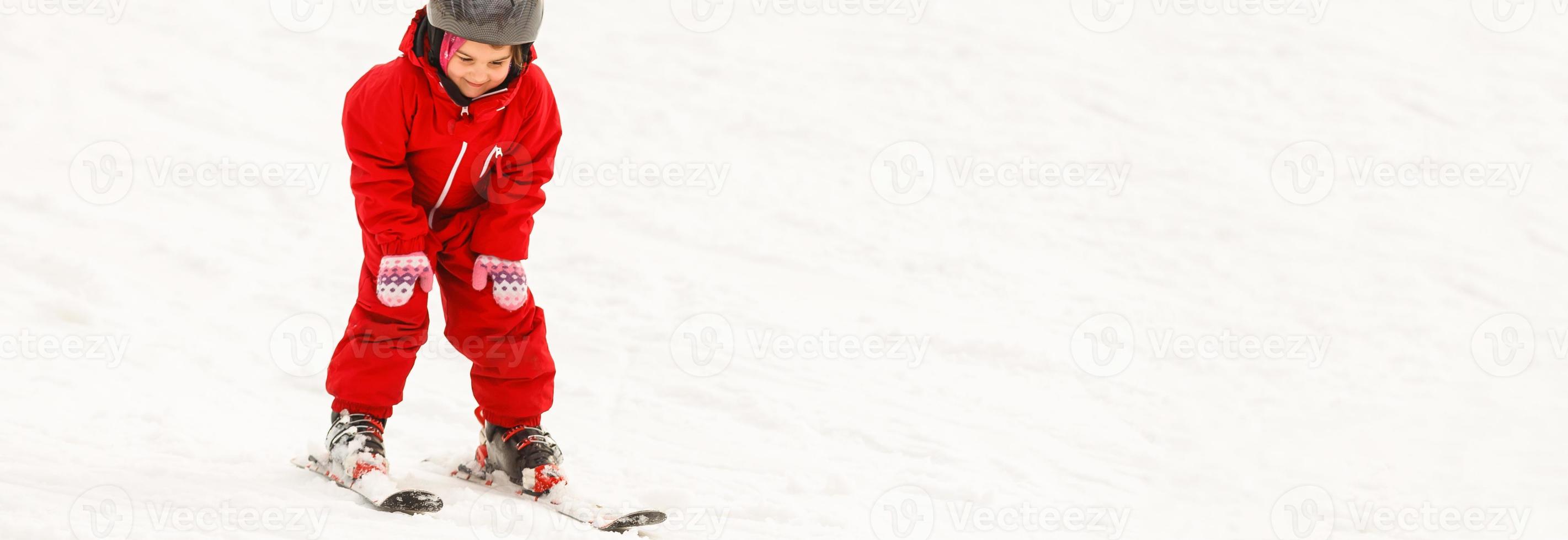 Ein professioneller Skilehrer bringt einem Kind an einem sonnigen Tag auf einem Berghang mit Sonne und Schnee das Skifahren bei. Familien- und Kinder-Aktivurlaub. foto