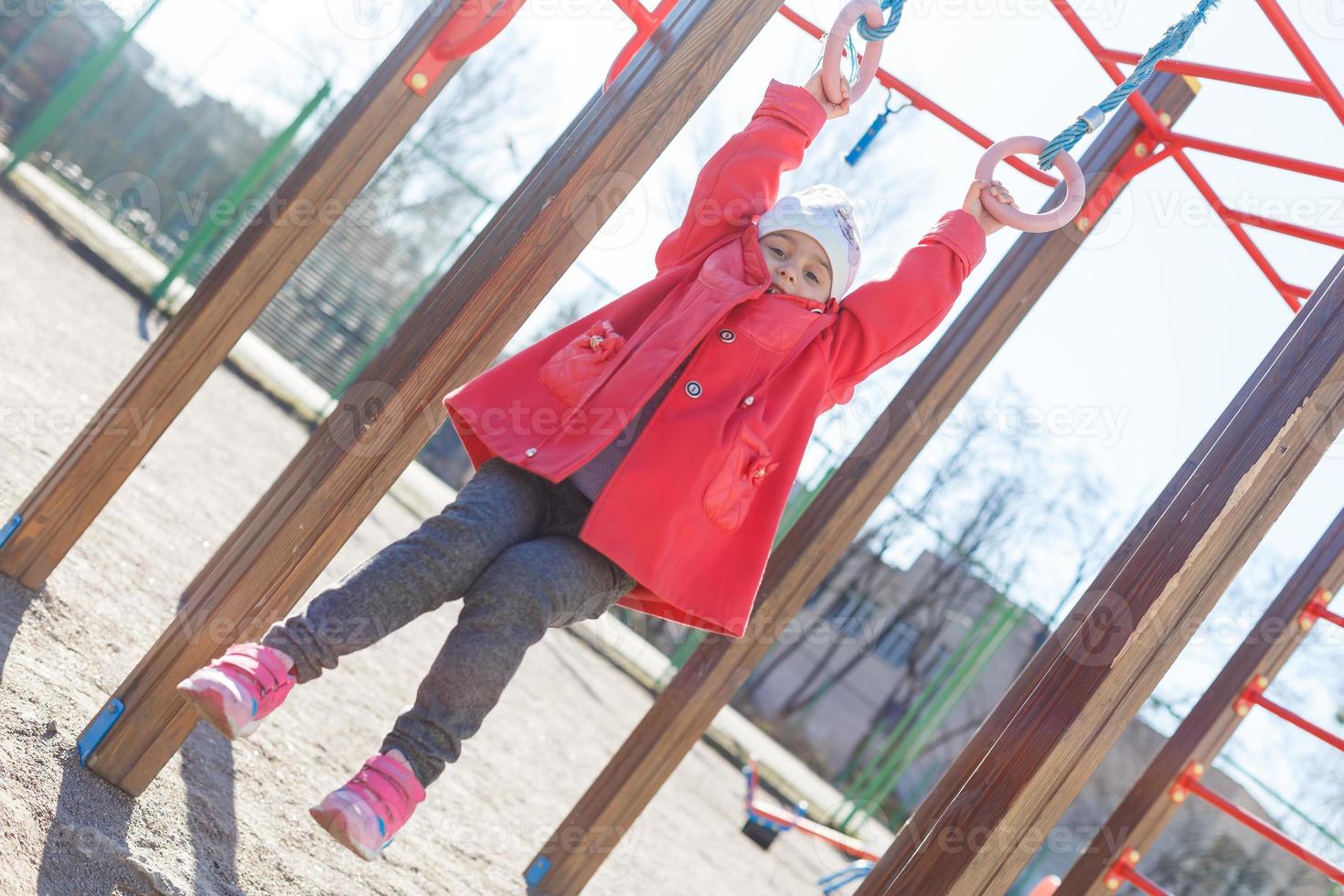 kleines Mädchen, das auf der horizontalen Stange spielt foto