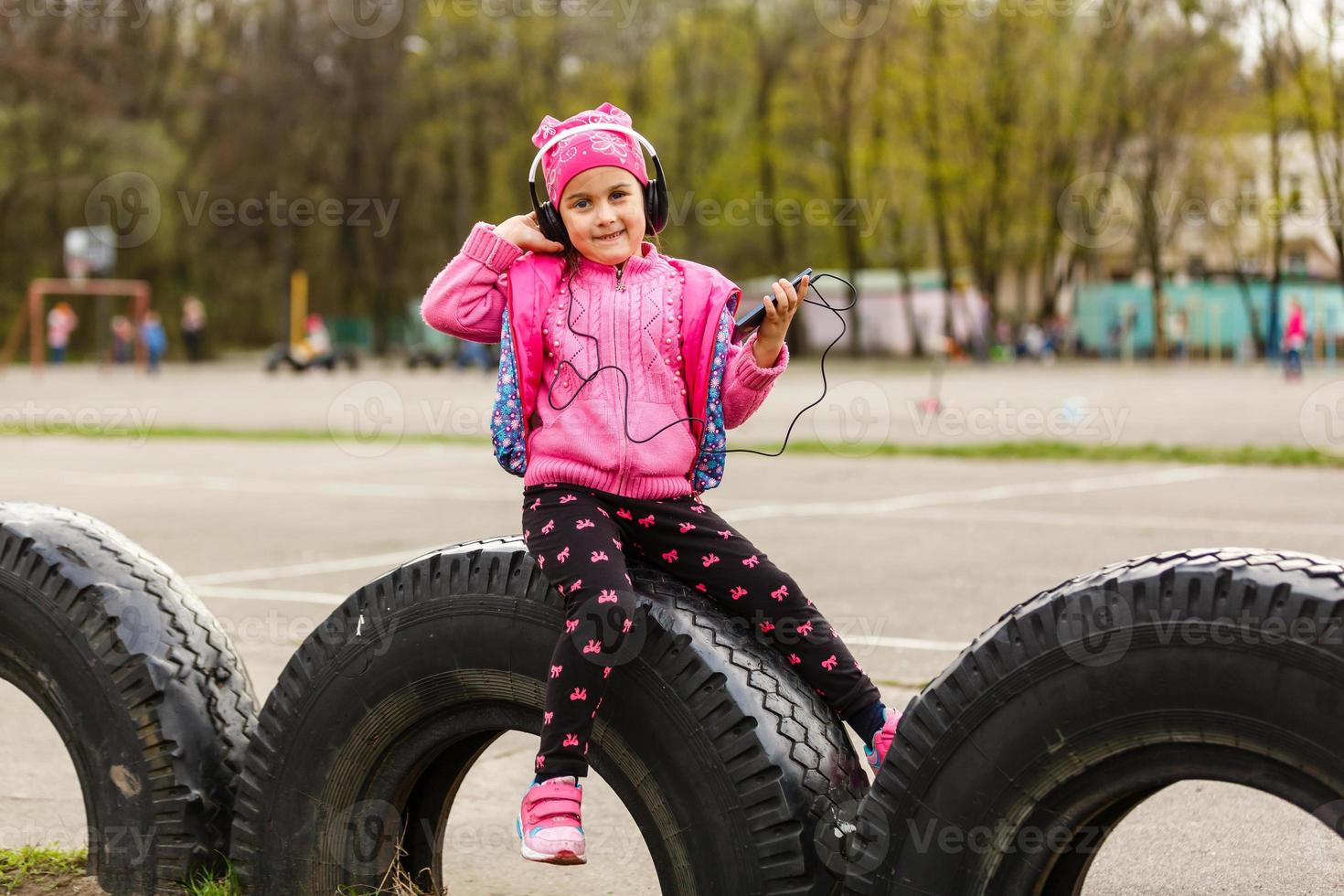 kleines schönes Mädchen genießt das Telefon. sie Kopfhörer. Kinder und Technik foto