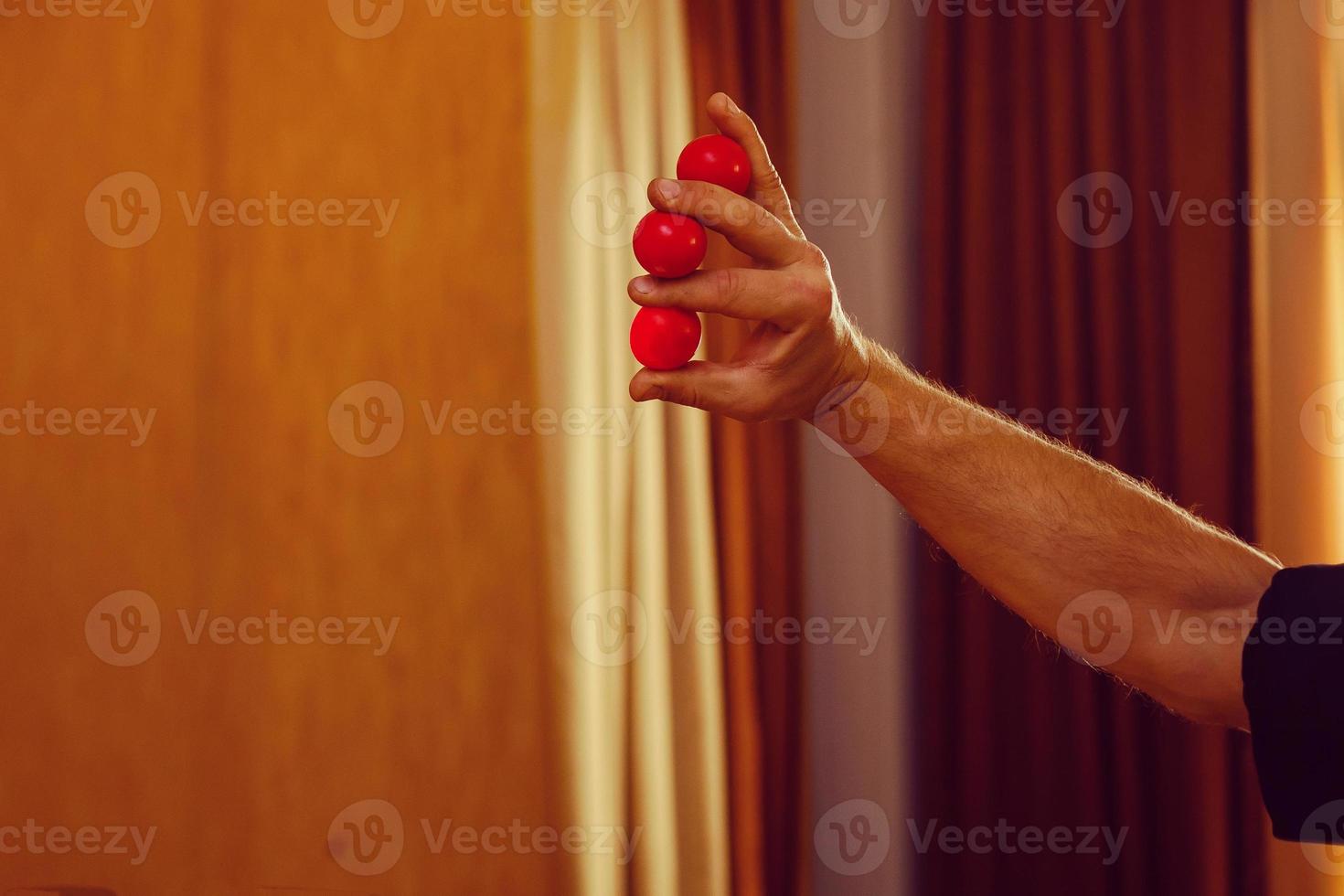 Zauberer, der Hand in Hand winkt, hat eine rote Kugelhülle foto