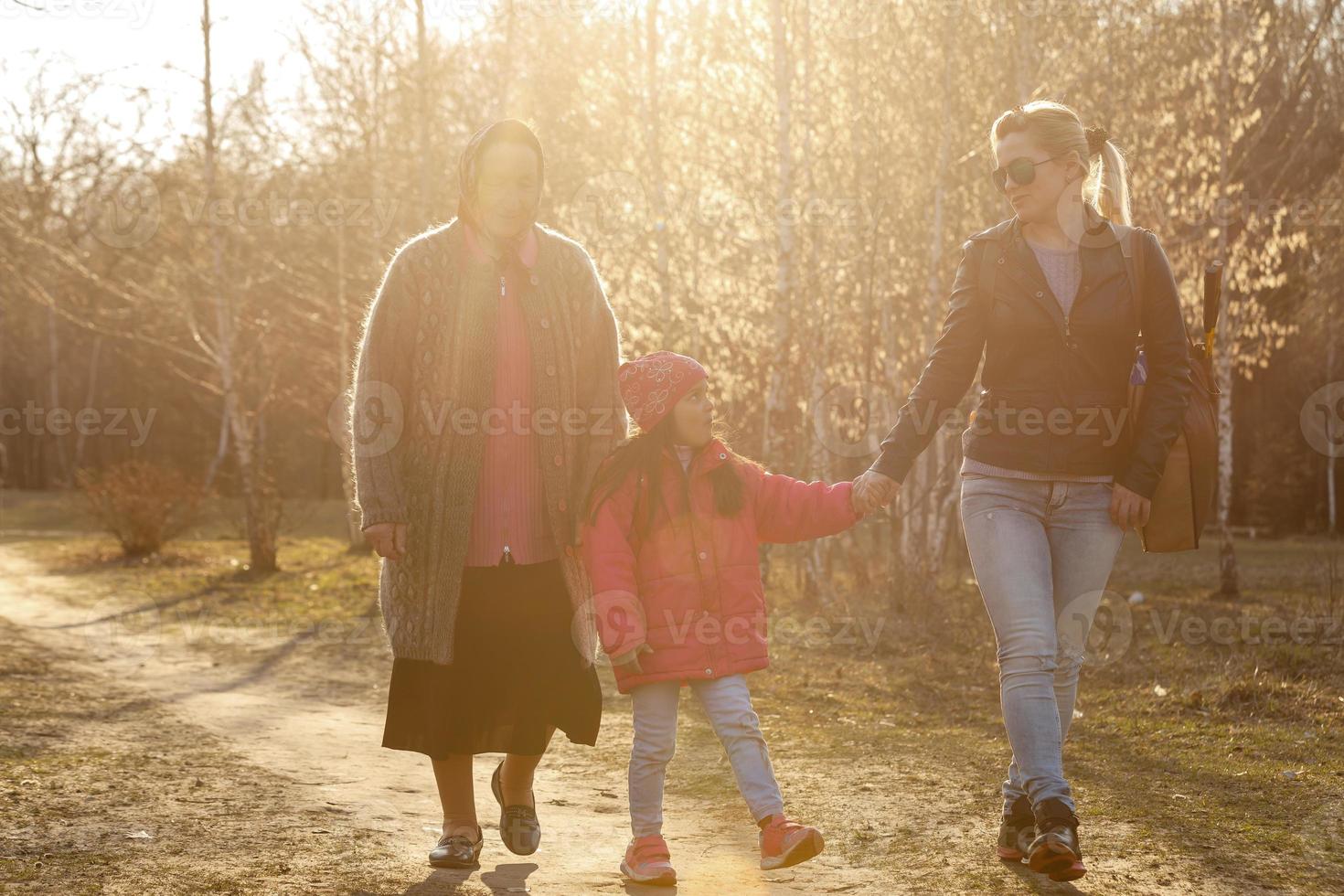 Familie, die an einem sonnigen Tag im Park spazieren geht foto