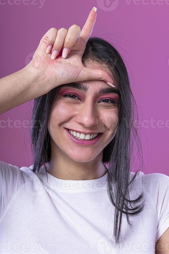 lächelndes brünettes mädchen, das ihr langes schönes haar flirtet und berührt foto