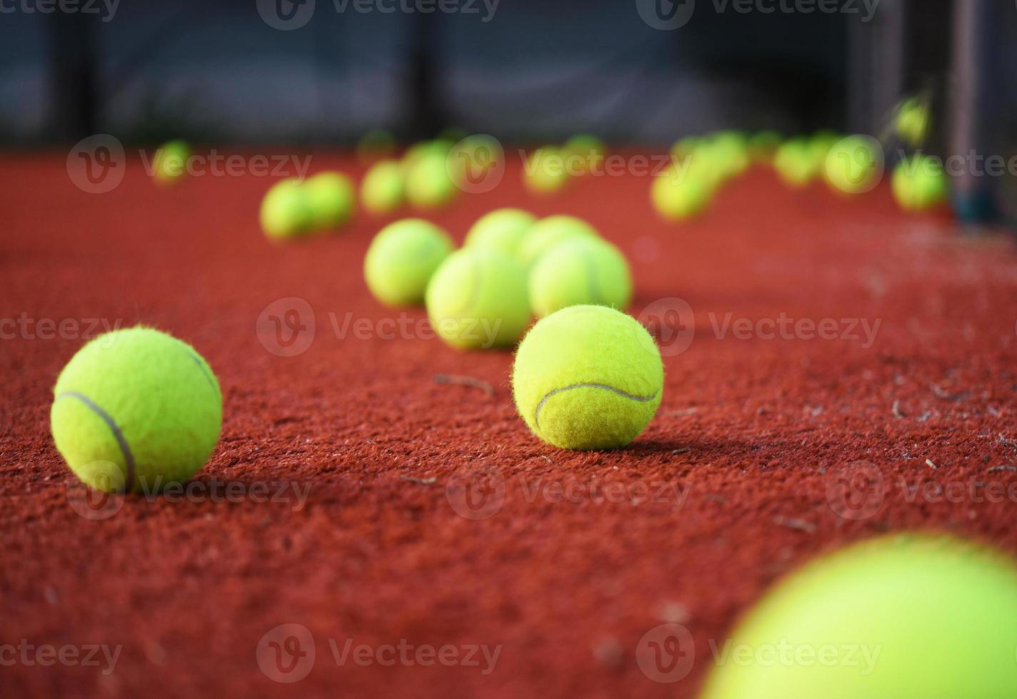 Tennisschläger mit Tennisbällen auf Sandplatz foto