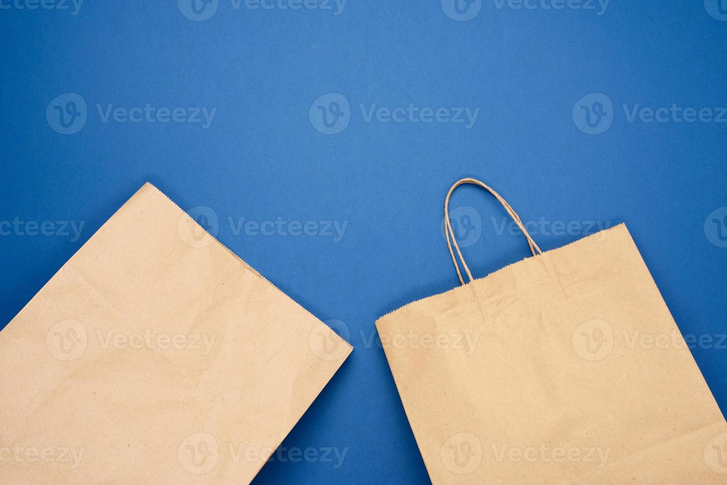 Einwegbeutel aus braunem Kraftpapier auf blauem Hintergrund, Konzept der Ablehnung von Kunststoffverpackungen foto