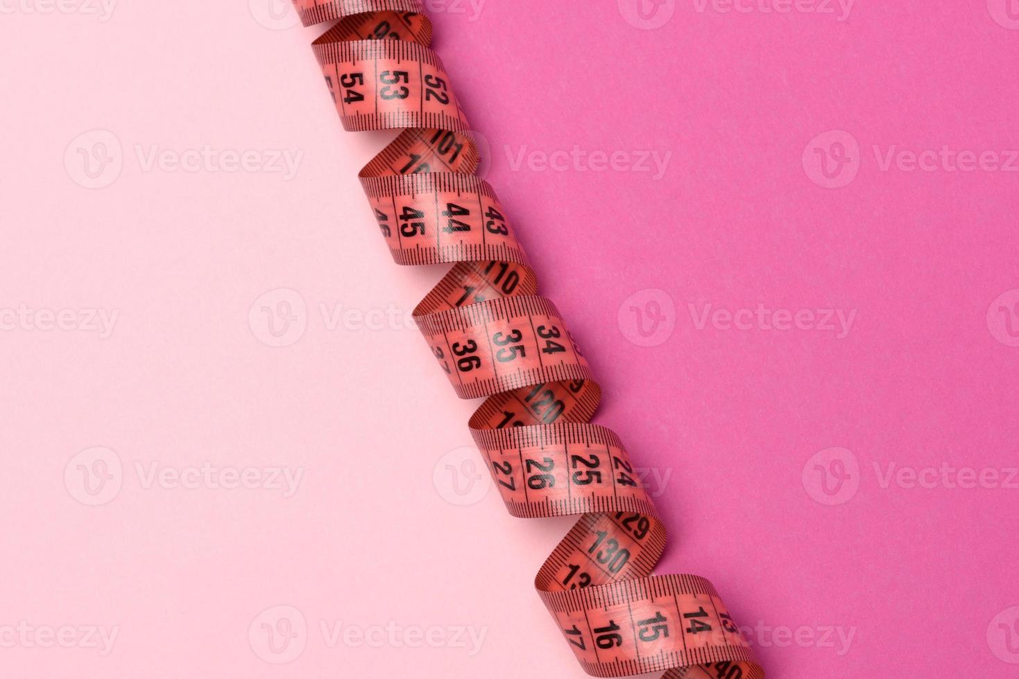 verdrehter roter Zentimeter auf einem rosa Hintergrund foto