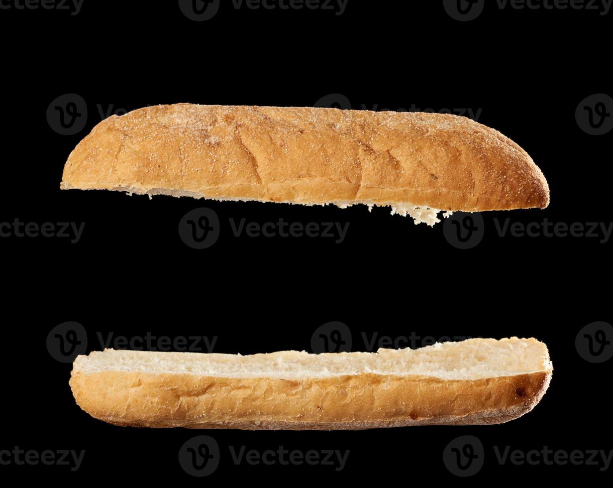halbiertes gebackenes Ciabatta-Laib isoliert auf schwarzem Hintergrund, Sandwich leer foto