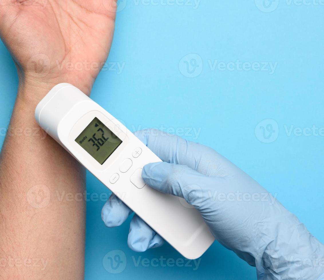 das Messen der Körpertemperatur am Handgelenk mit einem berührungslosen Thermometer foto