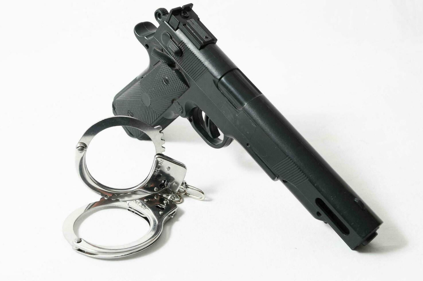 Konzept der Waffenkriminalität Waffe und Handschellen foto