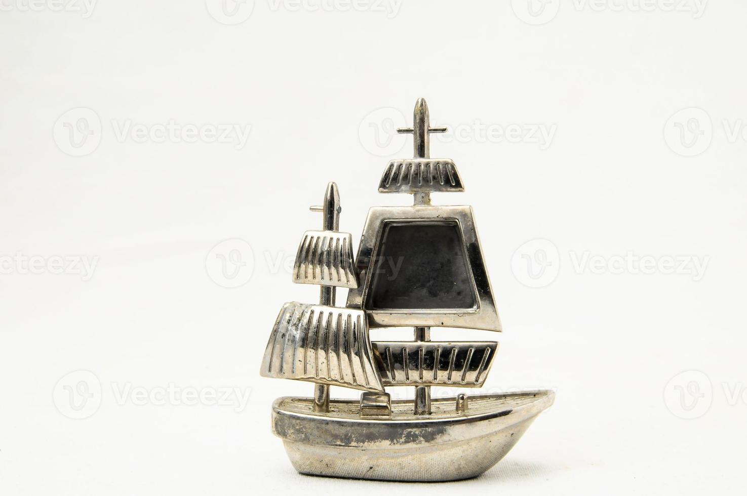Silber Miniatur-Segelboot auf weißem Hintergrund foto