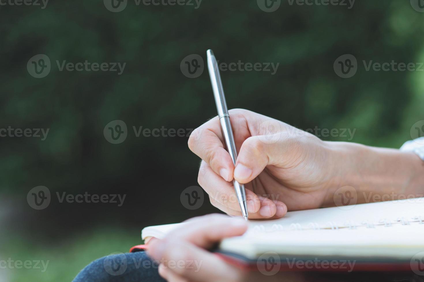 männliche hände mit stiftschreiben auf notizbuch foto