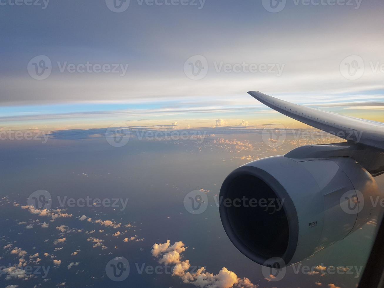 Blick vom Flugzeugfenster auf den Himmel im Abendlicht mit Flugzeugtriebwerk foto