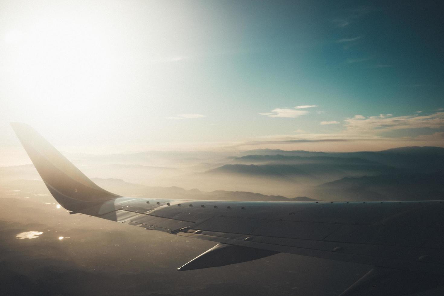 Flugzeugflügel über nebligen Bergen foto