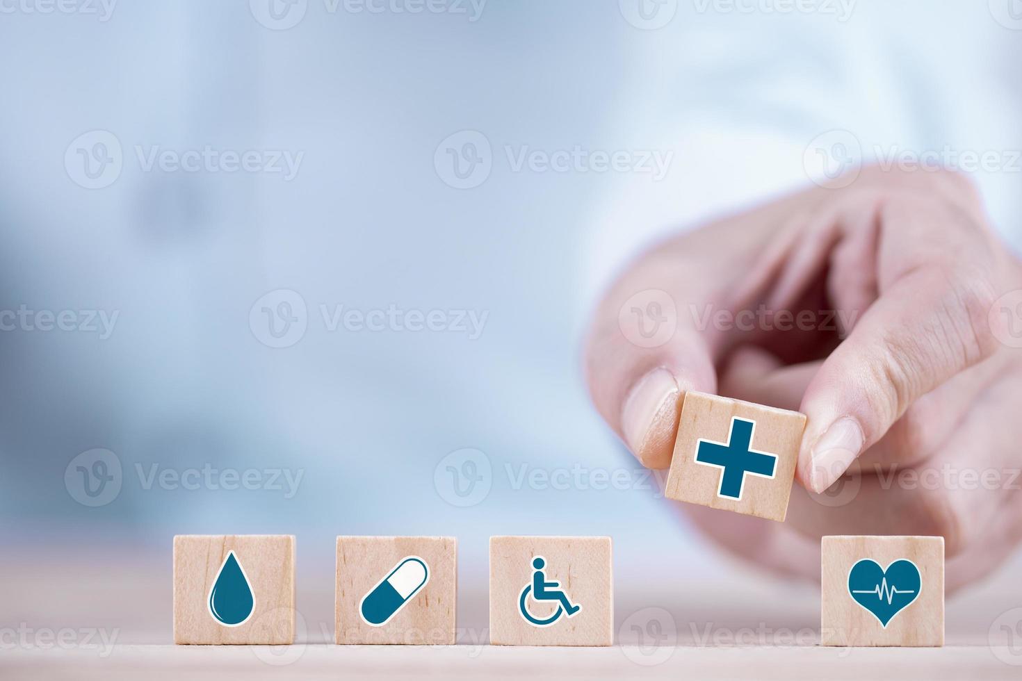 geschäftsmann wählt ein emoticon-ikonen-gesundheitswesen-medizinisches symbol auf holzblock-, gesundheits- und krankenversicherungskonzept foto
