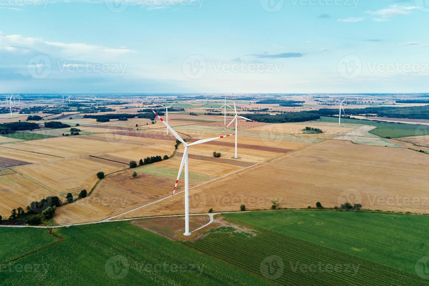 Windmühle zwischen landwirtschaftlichen Feldern. Windkraftanlage am Sommertag foto