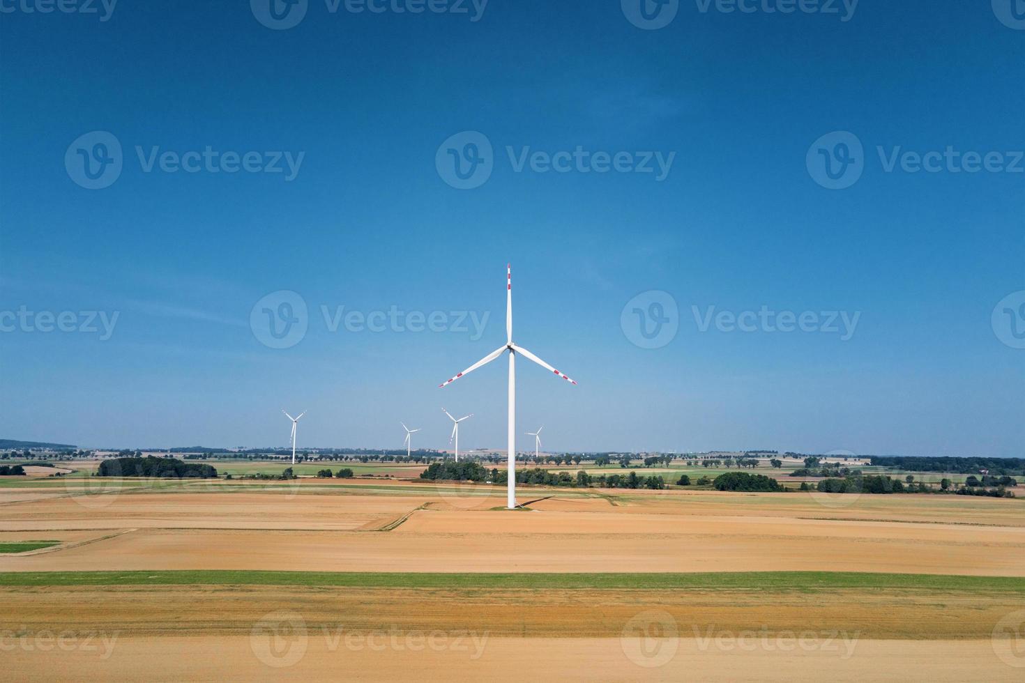 windmühlenturbine im feld am sommertag. drehender Windgenerator foto