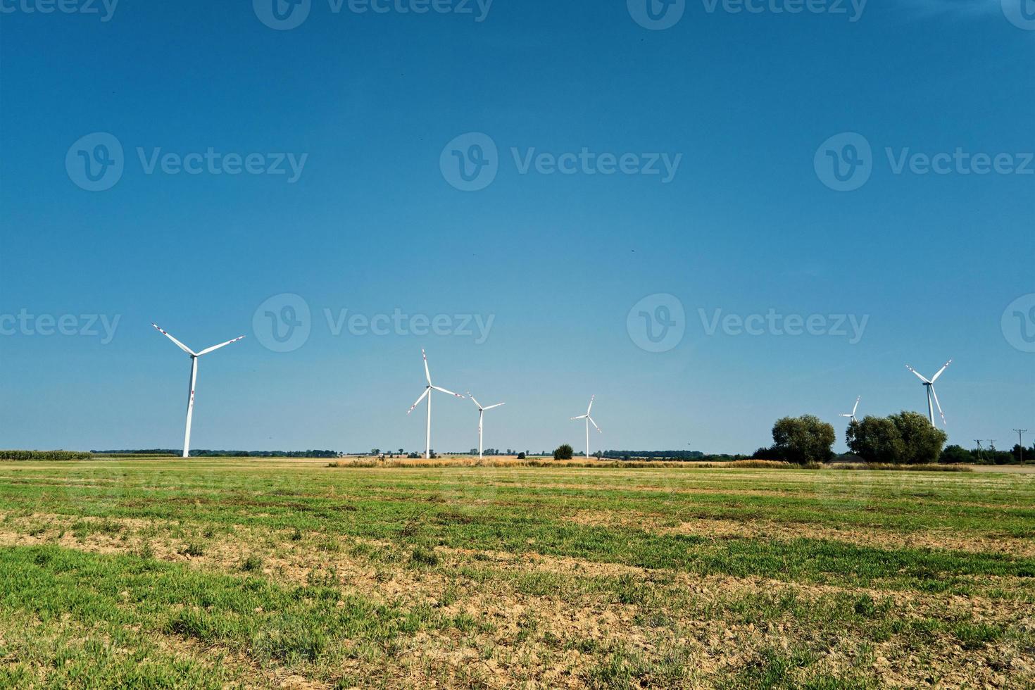 windmühlenturbine im feld am sommertag. drehender Windgenerator foto