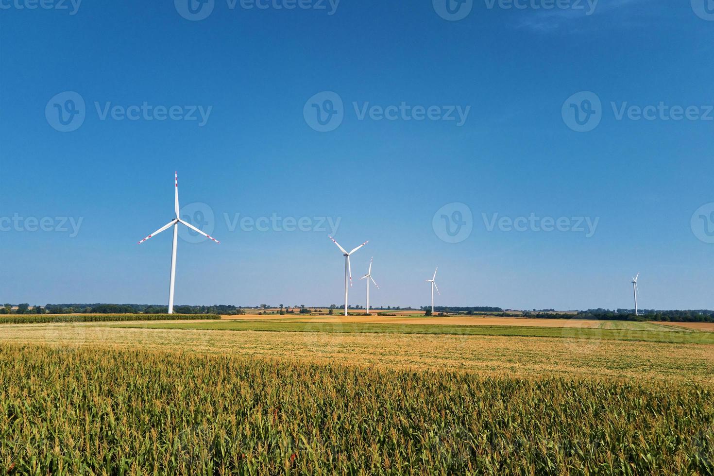 windmühlenturbine im feld am sommertag. drehender Windgenerator foto