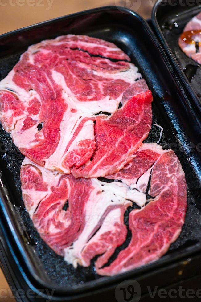 Frischfleisch-Chuck-Auge für Sukiyaki hautnah. Ansicht von oben. Schieben Sie rohes Rindfleisch für Yakiniku. dünnes stück rindfleisch für shabu hotpot japanischen essensstil. foto