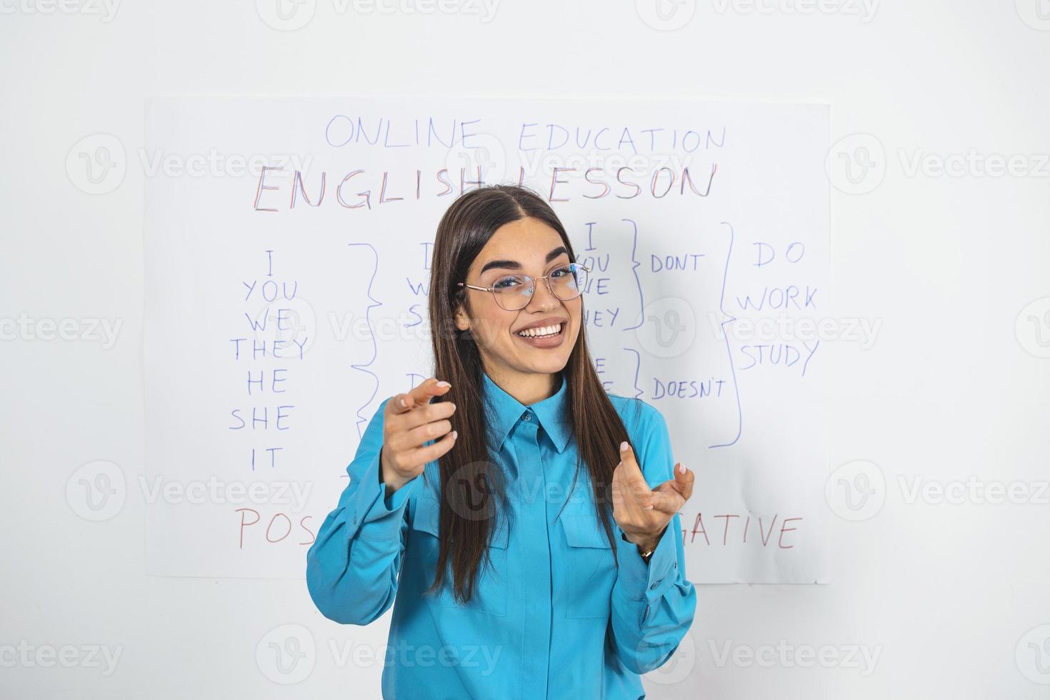 Englischlehrerin einer jungen Frau, die an einem Whiteboard steht und der Kamera eine Online-Lektion gibt. bildung zu hause in selbstisolierung während der quarantänesperre. foto