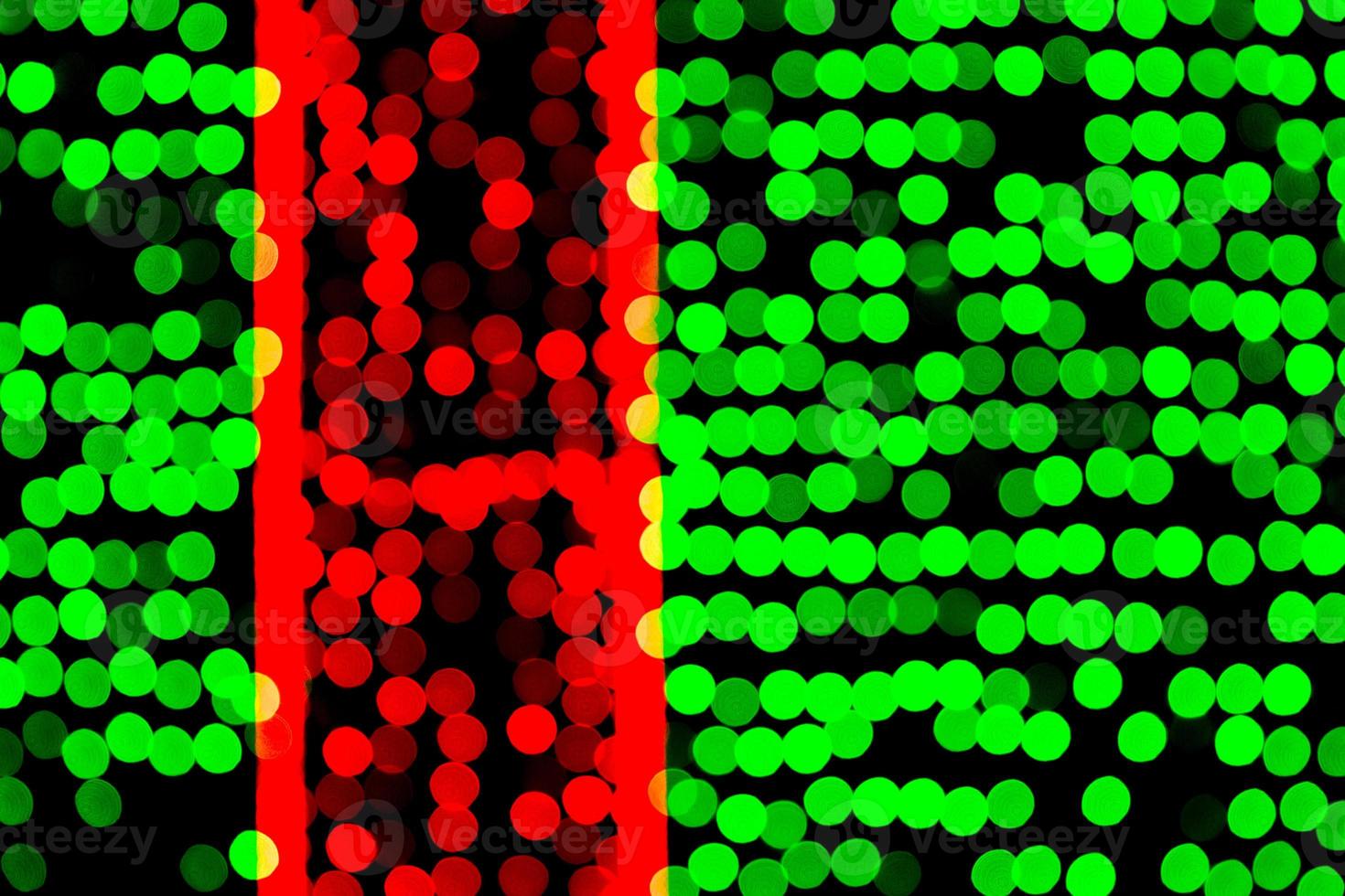 Unfokussiertes abstraktes grünes und rotes Bokeh auf schwarzem Hintergrund. defokussiert und verschwommen viele runde licht foto