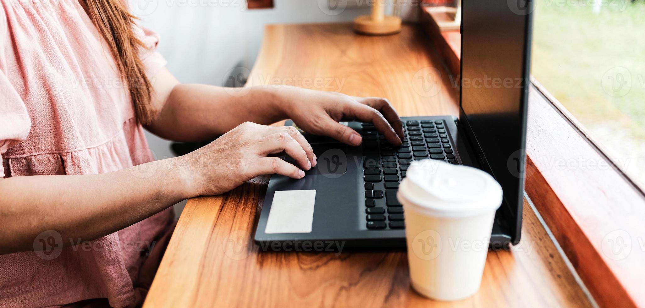 nahaufnahme der hände der frau, die auf einem laptop tippen.geschäftsfrau, die an einem laptop arbeitet, dame, die computerkonzept verwendet, um e-mails zu schreiben, online zu kommunizieren, während sie an einem tisch in einem gemütlichen café sitzt. foto