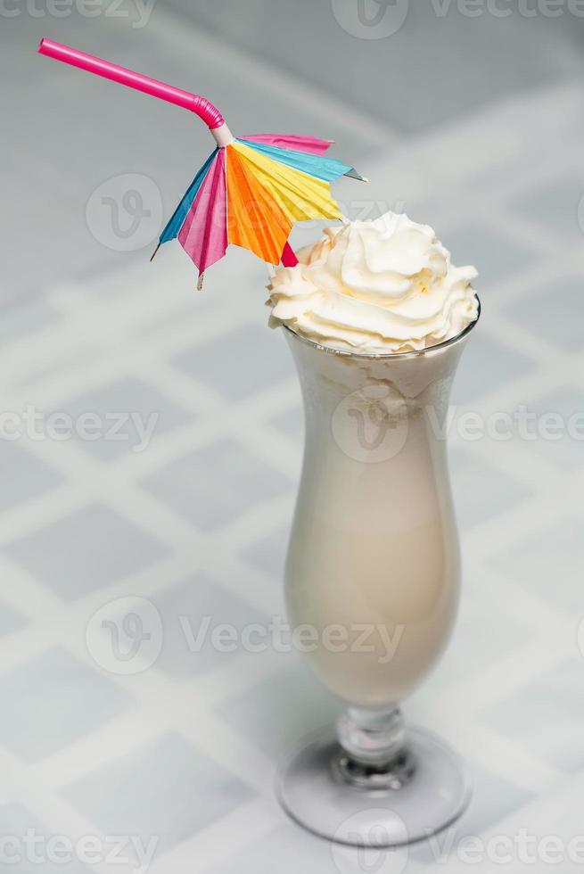 Milchshake in einem Glas mit einem Strohhalm auf dem Tisch foto