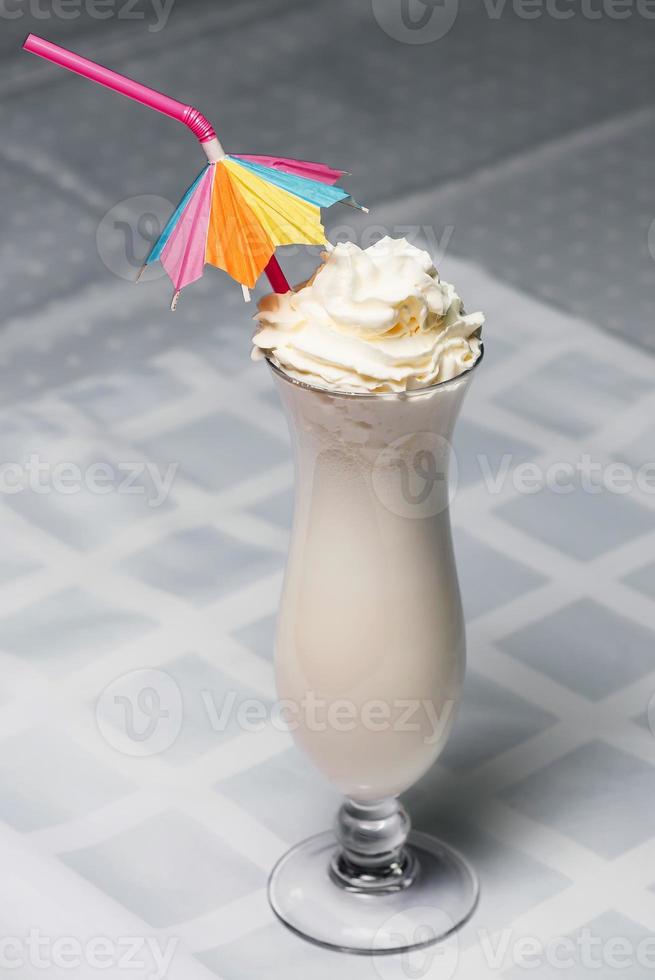 Milchshake in einem Glas mit einem Strohhalm auf dem Tisch foto