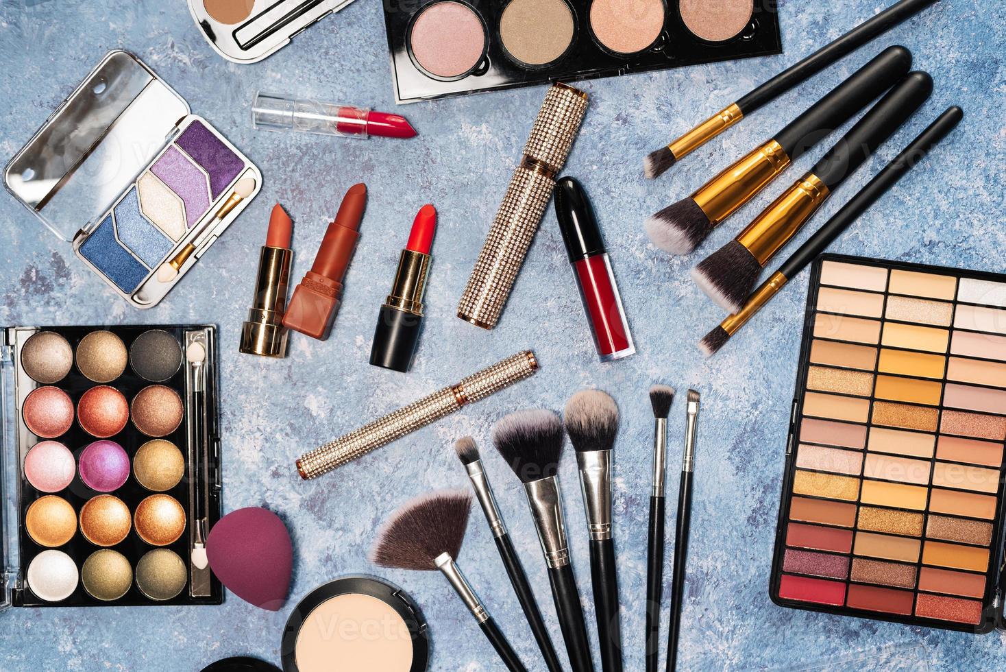 verschiedene make-up-produkte, pinsel auf blauem hintergrund foto