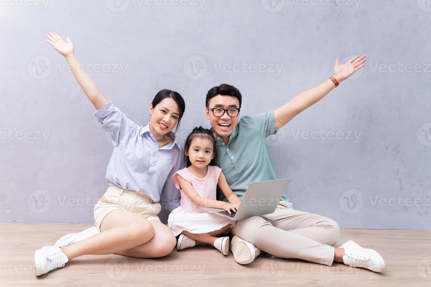 junge asiatische familie, die auf dem boden sitzt foto