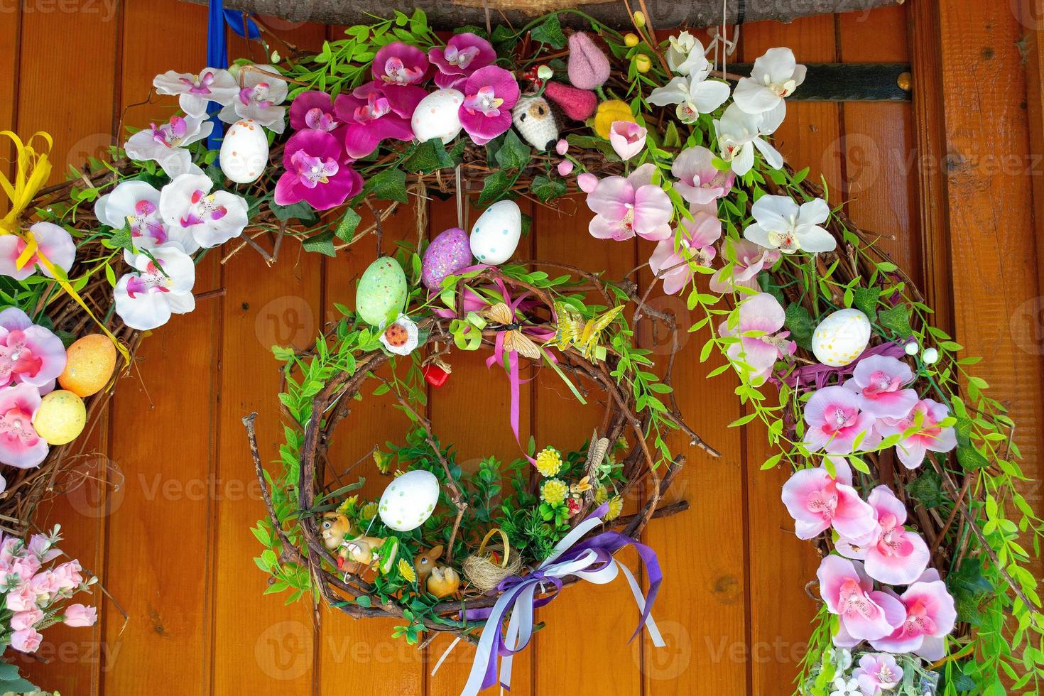 Ostereier-Kranz mit Blumen an der Haustür. traditionelle dekoration für ostern. foto