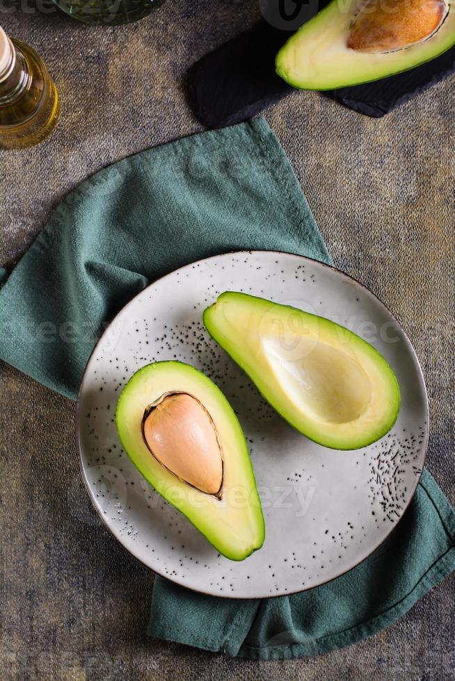 Avocadohälften auf einem Teller auf dem Tisch. gesunde Vitaminernährung. Ansicht von oben und vertikal foto