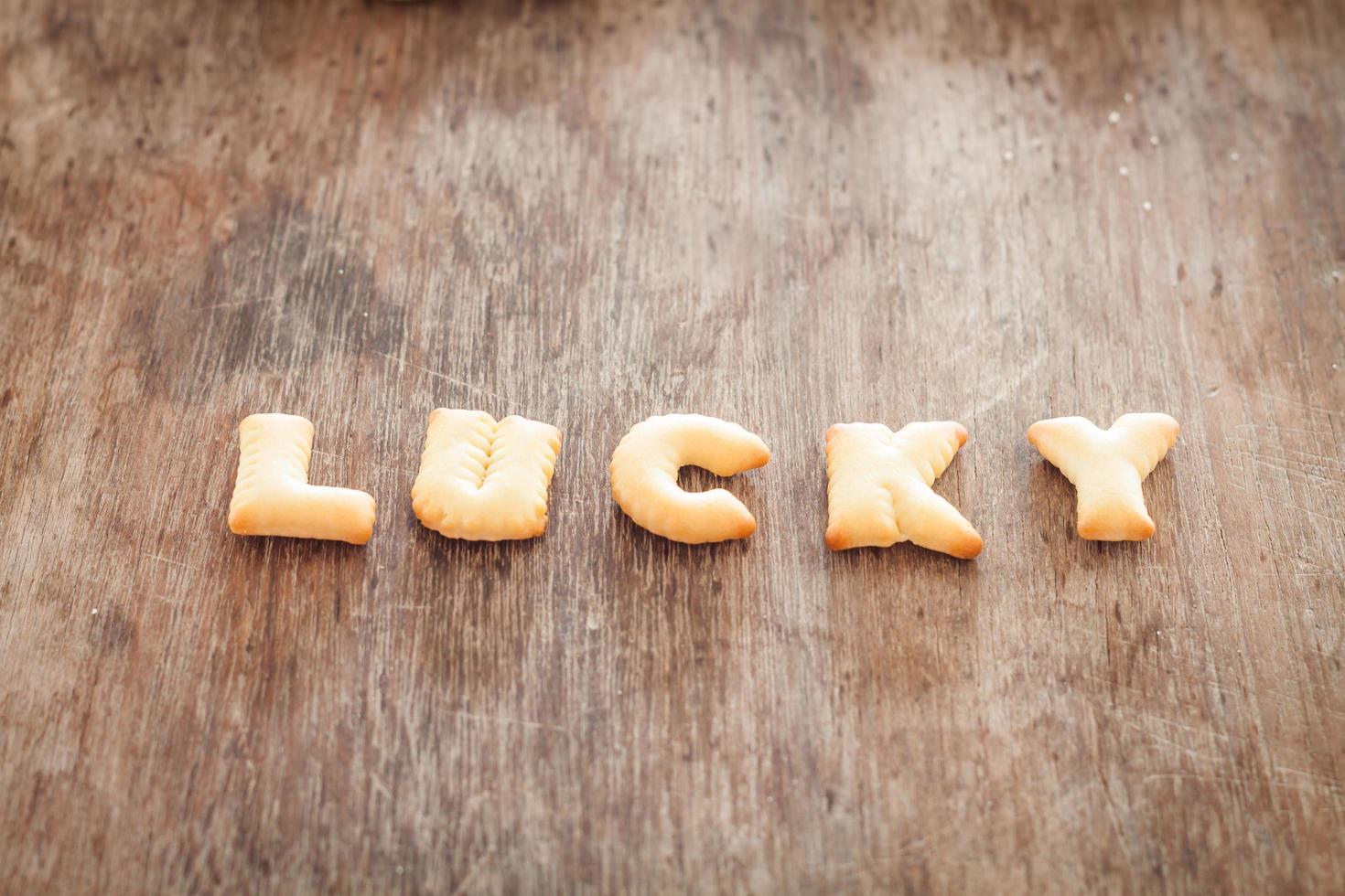 glückliche Alphabetplätzchen auf einem Holztisch foto