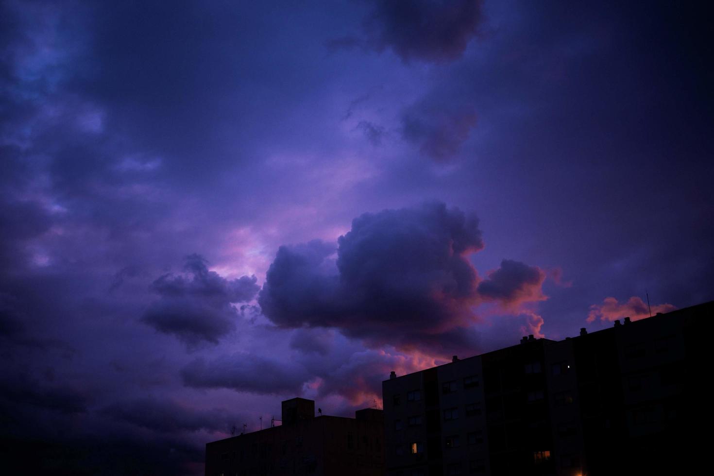 launischer Sonnenuntergangshimmel über silhouettiertem Gebäude in der Dämmerung foto