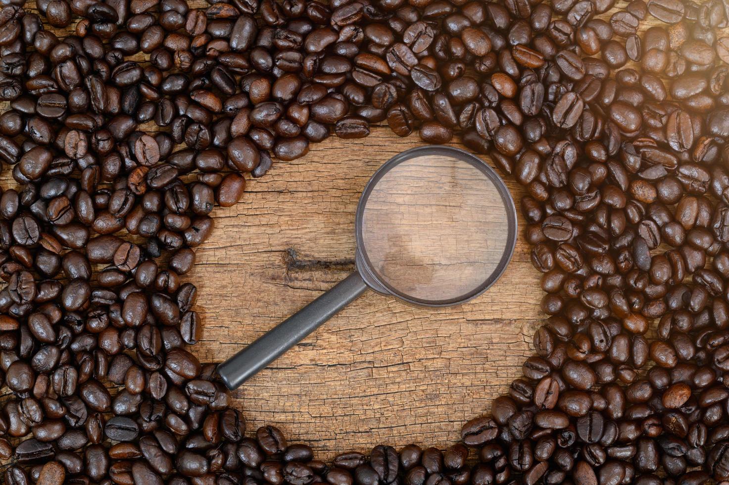 Holzschreibtisch mit Kaffeebohnen und Lupe foto