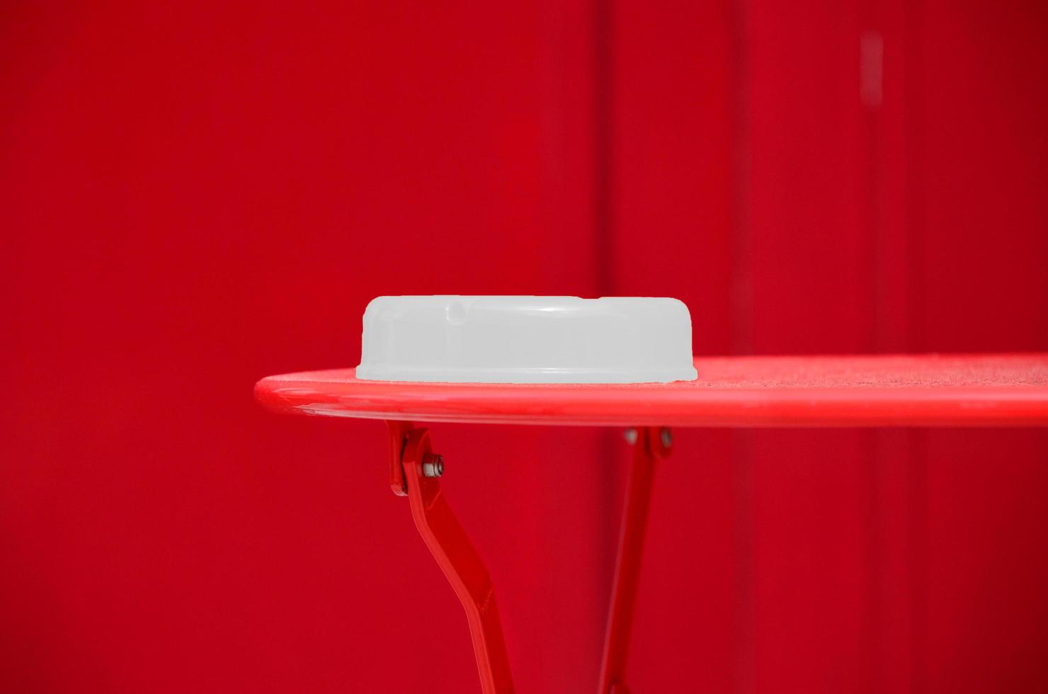 weißer Plastikbehälter auf einem roten Tisch foto