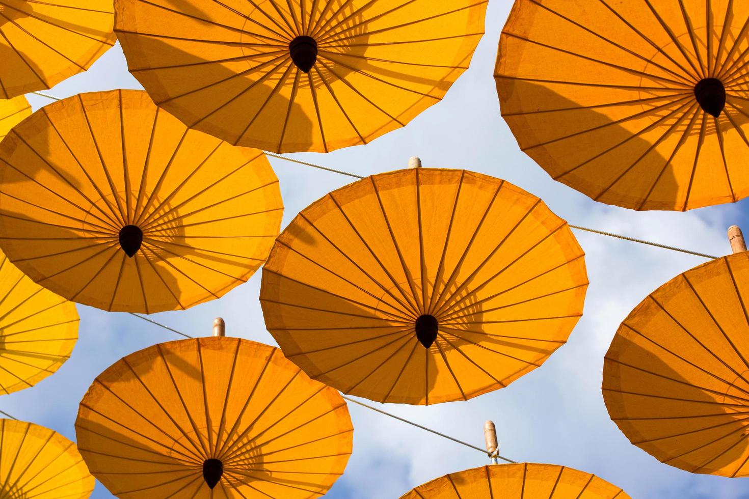 Viele Dekorationen mit hängendem gelben Regenschirm im Freien foto