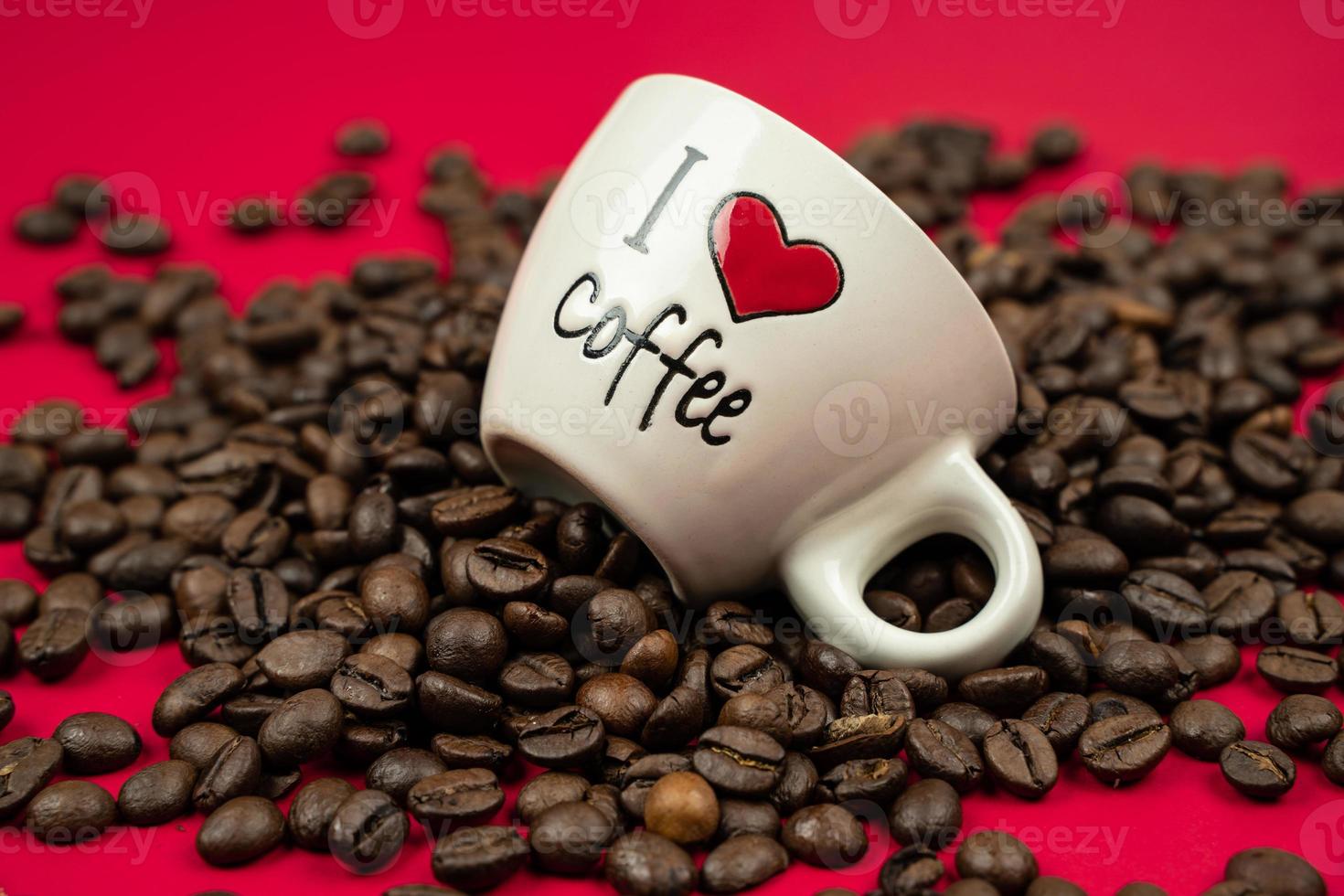 Ein mit Kaffeebohnen gefüllter Becher auf rotem Hintergrund mit der Aufschrift Ich liebe Kaffee foto
