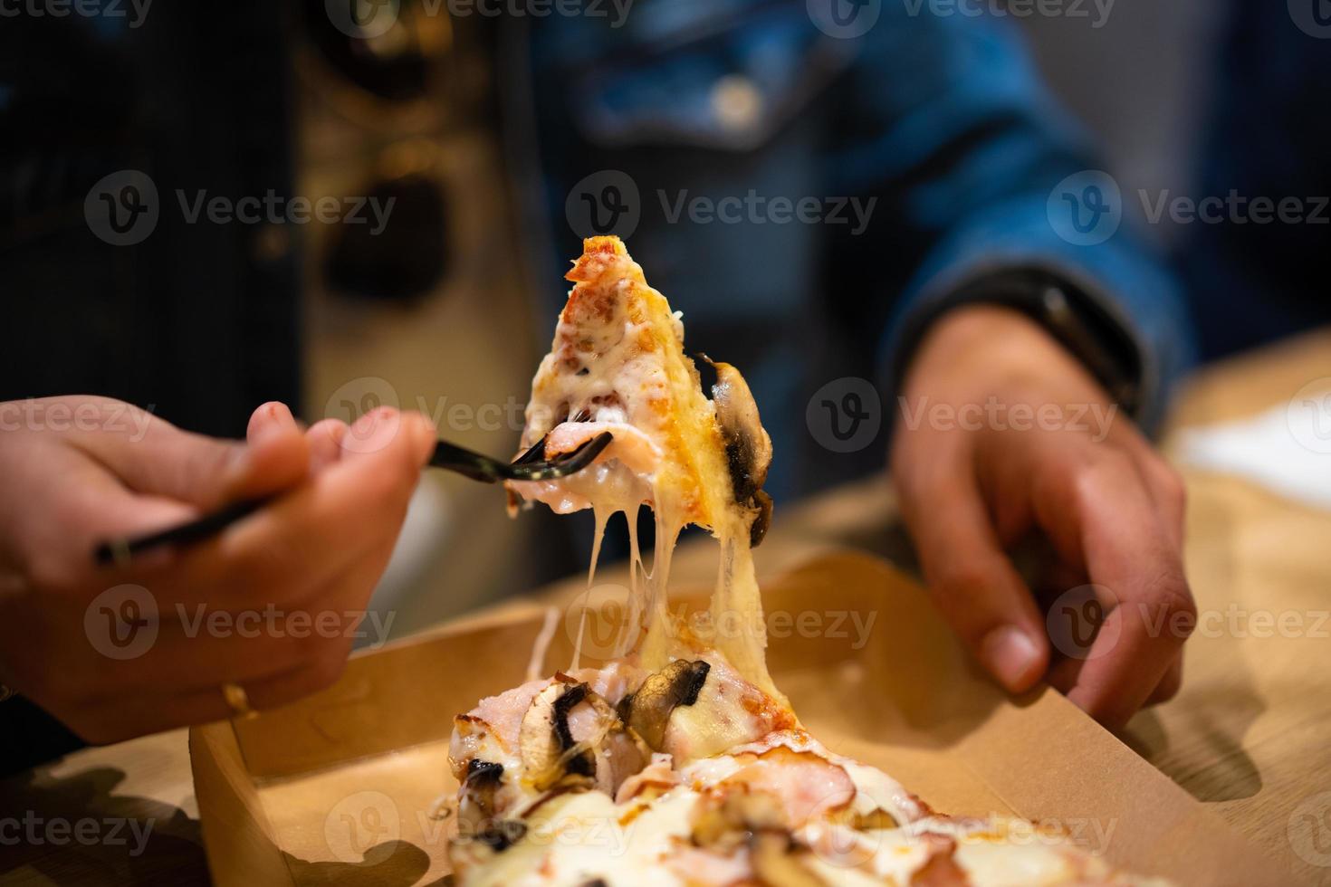 ein Stück Pizza mit geschmolzenem Käse, das sich ausdehnt foto