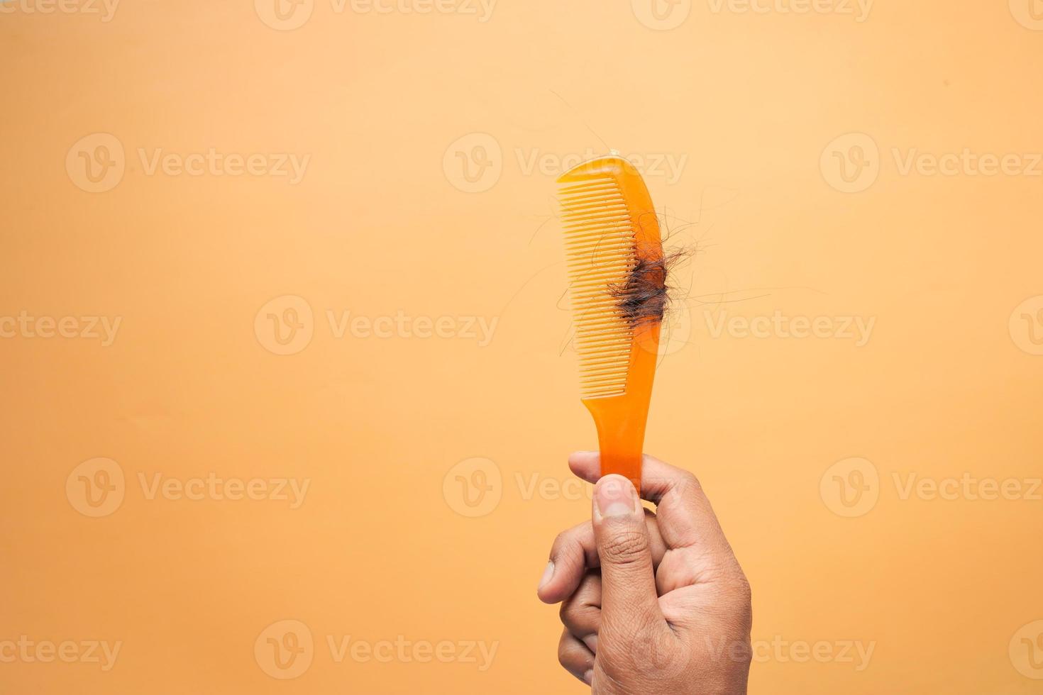 Haarausfall in orangefarbenem Kamm, Haarausfall im Alltag, ernstes Problem, foto