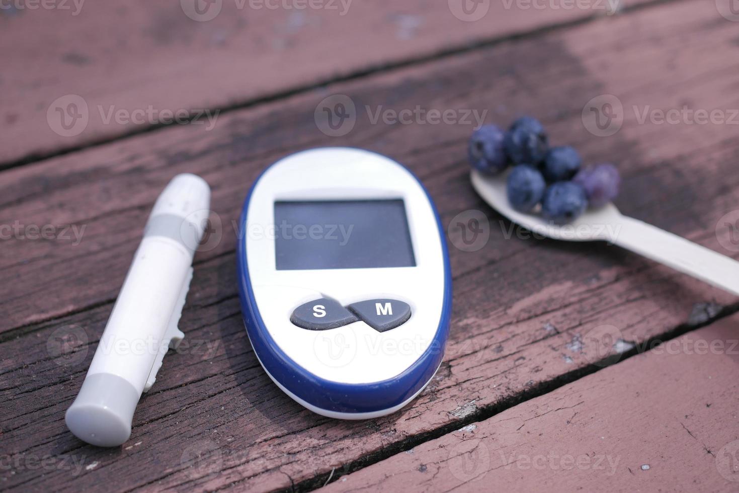 Nahaufnahme von diabetischen Messinstrumenten und blauen Beeren auf dem Tisch foto
