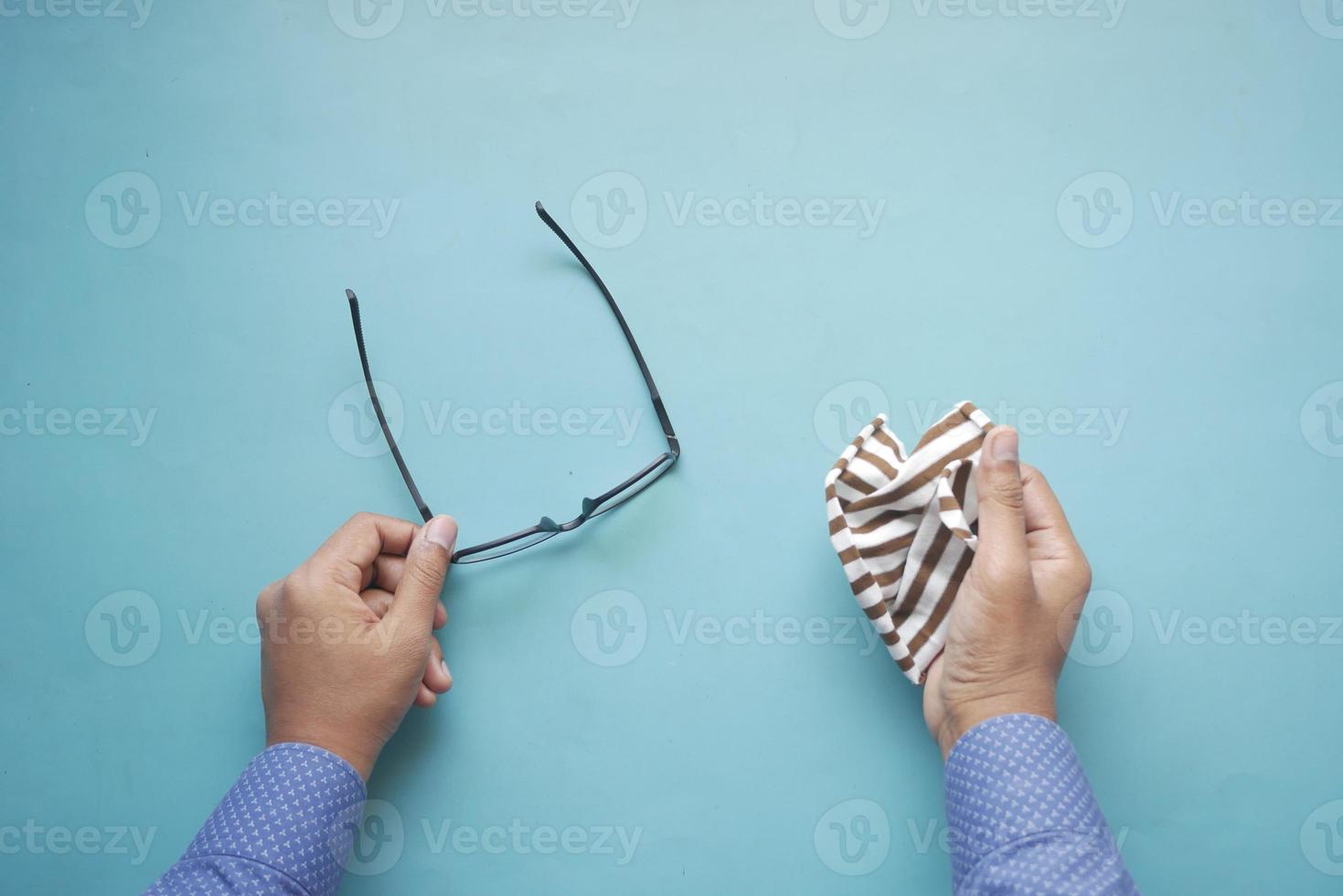 Brille mit Taschentuch aus nächster Nähe reinigen foto